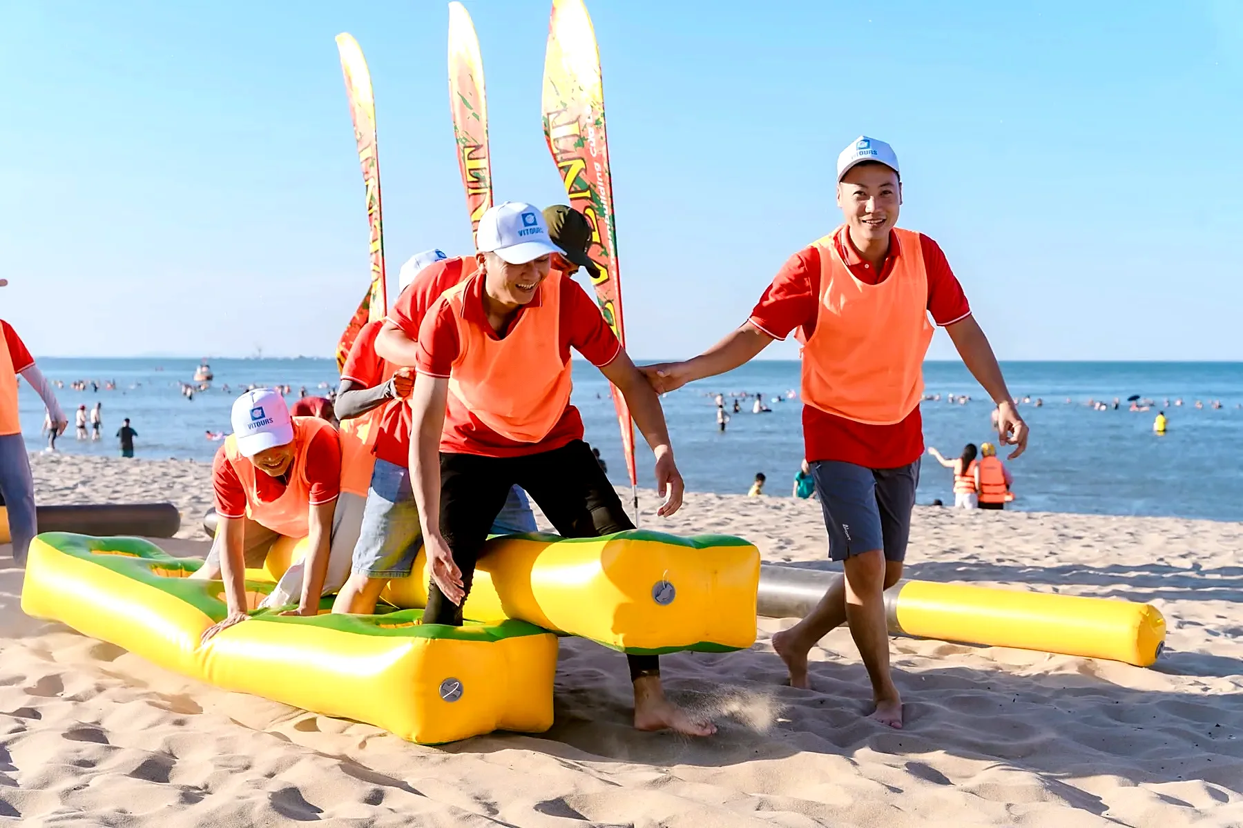 Team members racing over inflatable obstacles