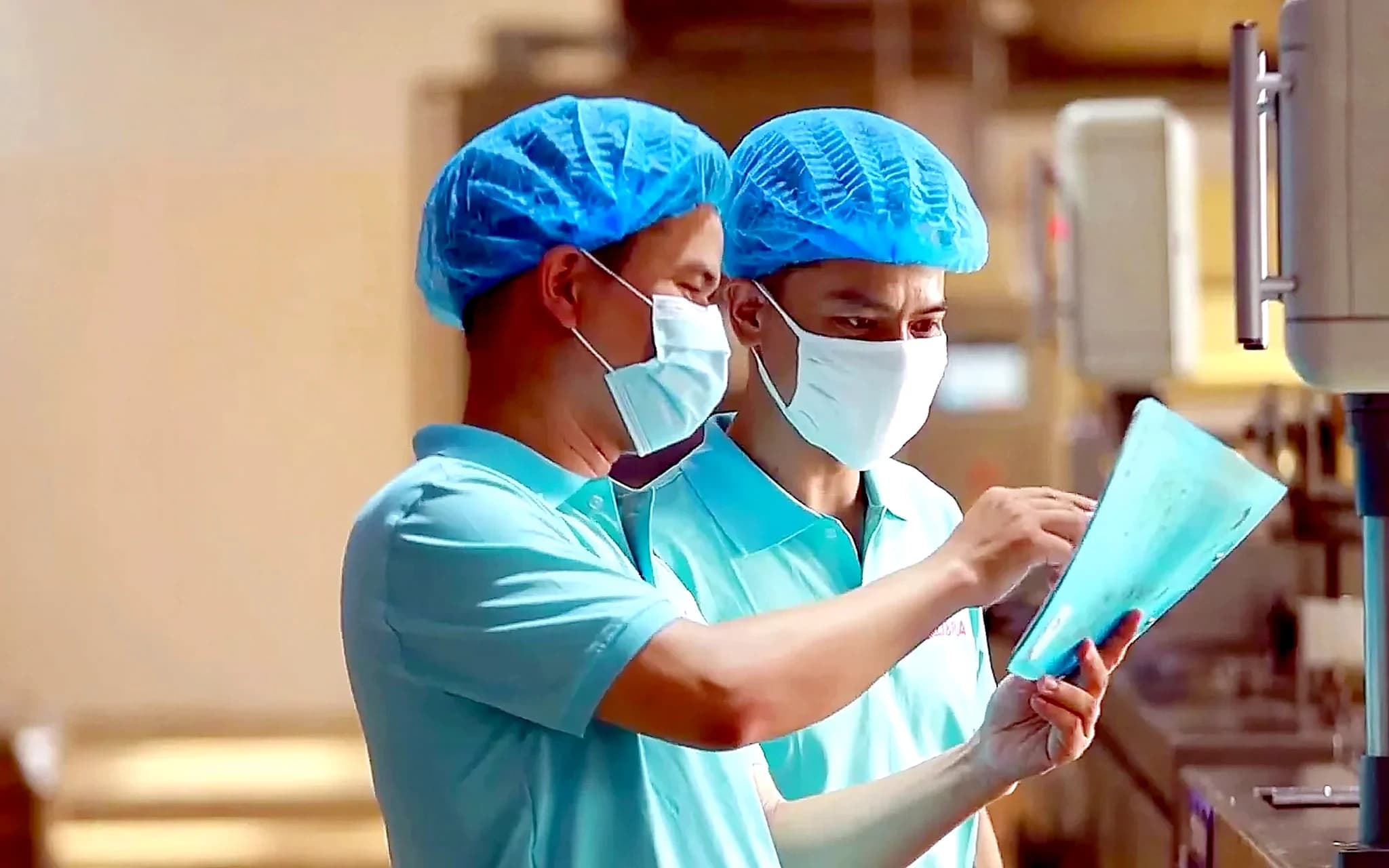 Two technicians checking a production spec sheet
